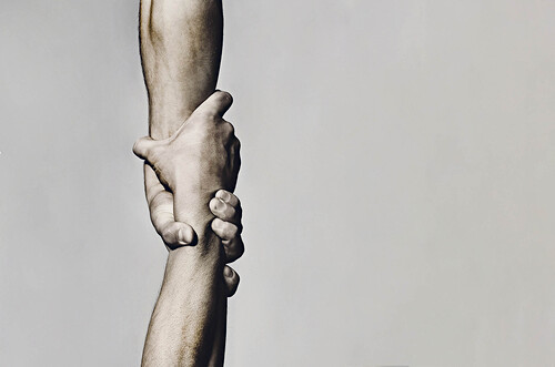 Helping hand concept and international day of peace, support. Helping hand outstretched, isolated arm, salvation. Close up help hand. Two hands, helping arm of a friend, teamwork. Black and white.