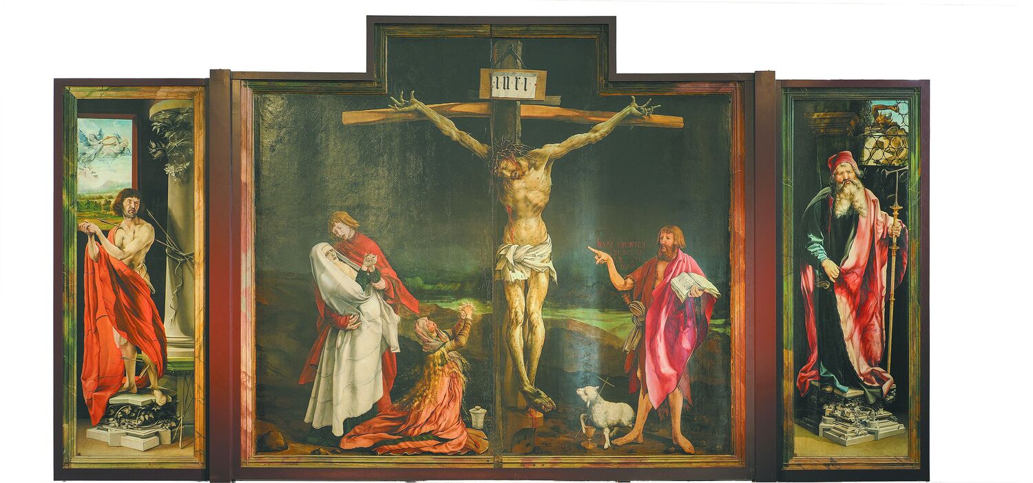 Johannes verweist mit dem langen Finger auf den Gekreuzigten. 