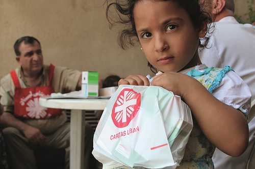 Laura Sheahen/Caritas A doctor who mans a Caritas 'mobile clinic' examines Syrian refugee children in Baalbek, Lebanon. Many refugee families are living in unsanitary conditions; children come to the doctor because of diarrhea, coughing, lice, and other problems.In summer