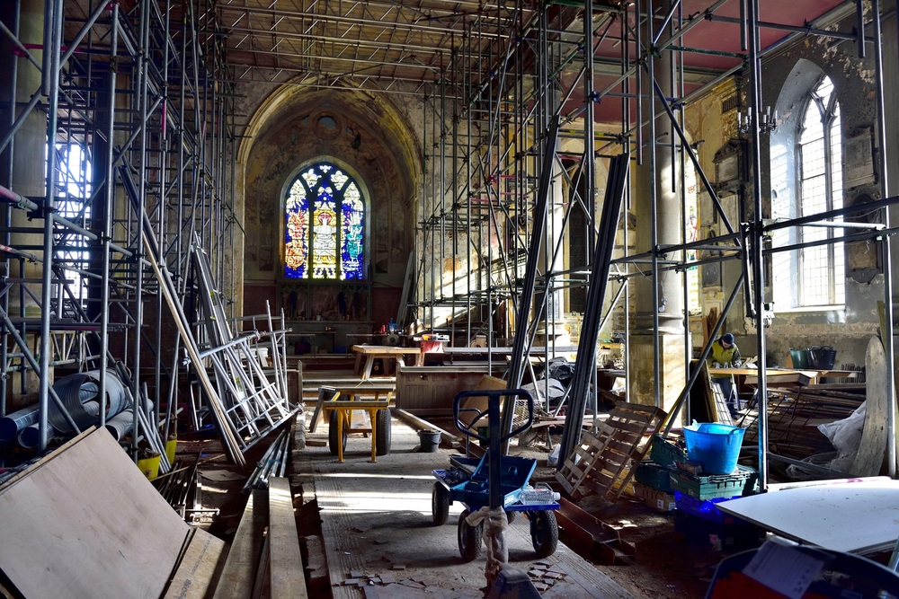 2B045YX Restoration building site with interior scaffolding and tools in old fire damaged church building being repurposed, England, UK,