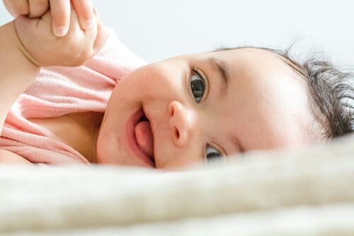 unsplash / Daniel Thomas https://unsplash.com/de/fotos/baby-im-rosa-hemd-liegt-auf-weissem-textil-_tYNzEqehMkhttps://unsplash.com/de/@soy_danielthomas